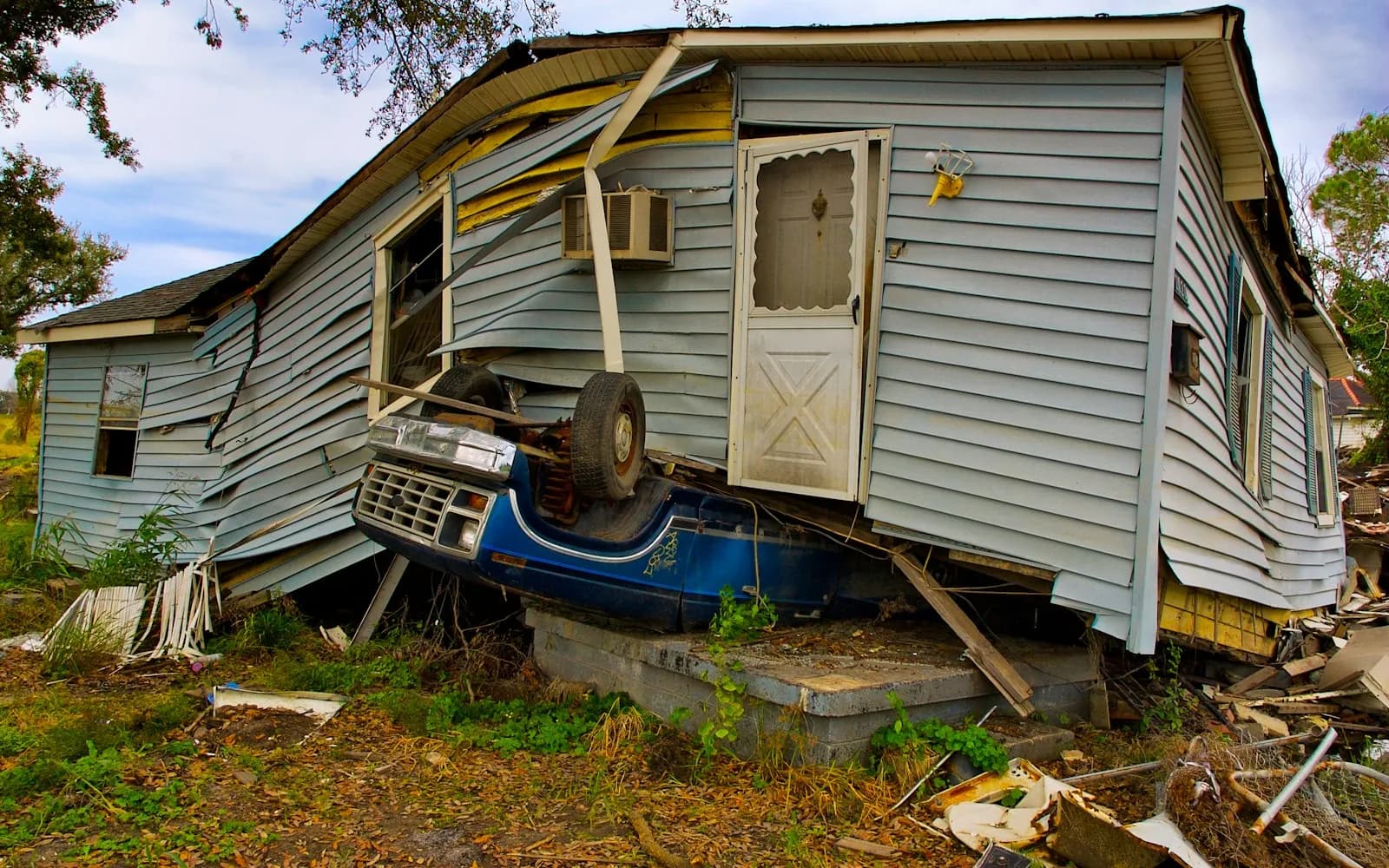Person photographing storm damage on a house exterior