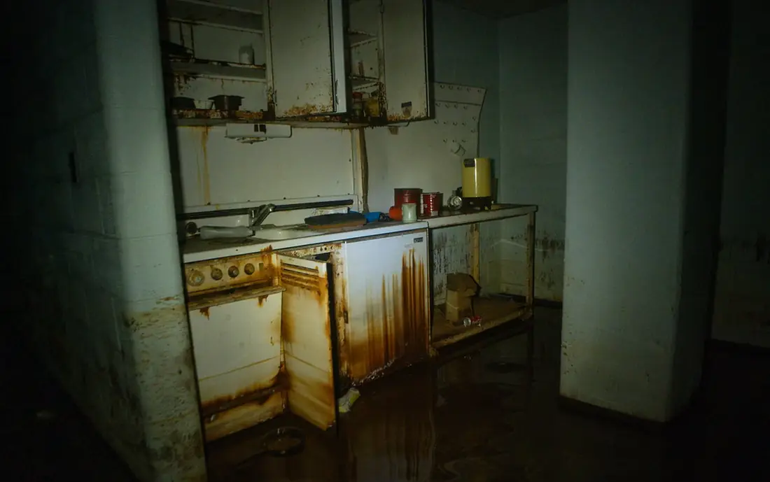 Flooded kitchen interior with standing water covering the floor