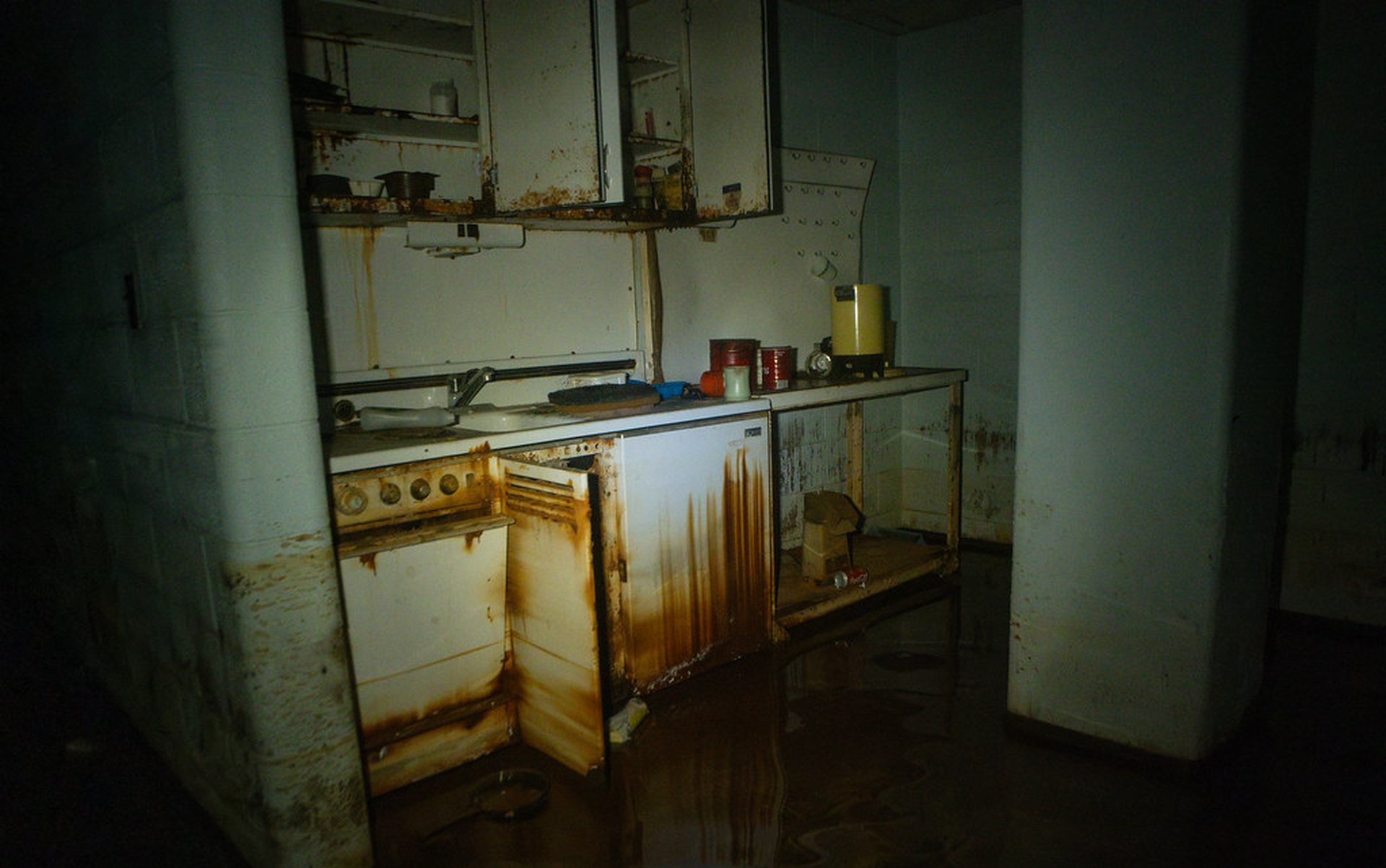 Flooded kitchen interior with standing water covering the floor